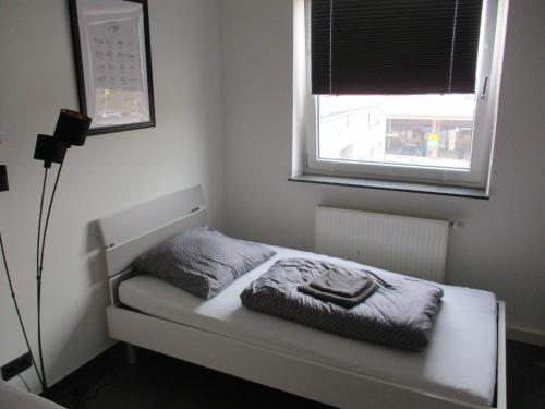 uma pequena cama num quarto com uma janela em PARSBERGER STADTWOHNUNG 3 em Parsberg