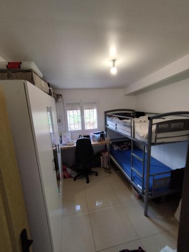 Ce dortoir comprend un bureau et des lits superposés. dans l'établissement Jeux olympiques 24, à Goussainville