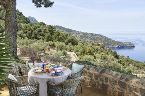 stół z jedzeniem i widokiem na ocean w obiekcie Villa Can Miquelet Deia w mieście Deia