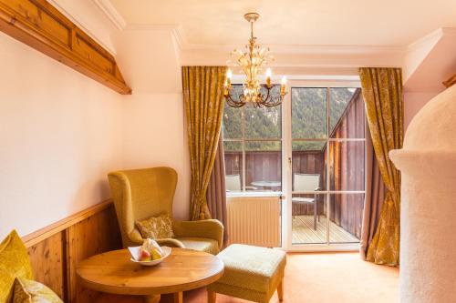 a living room with a table and chairs and a window at Via Salina - Hotel am See - Adults Only in Haldensee