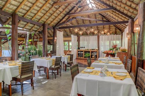 a dining room with white tables and chairs at Aldeia da Mata Ecolodge in Serra Grande