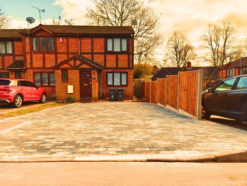 um parque de estacionamento em frente a uma casa de tijolos em Modern Spark Home with parking, garden, Wi-Fi em Birmingham