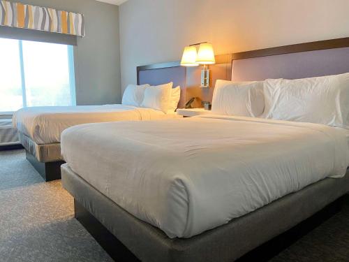 ein Hotelzimmer mit 2 Betten und einem Fenster in der Unterkunft Hampton Inn Mcminnville, Tn in McMinnville