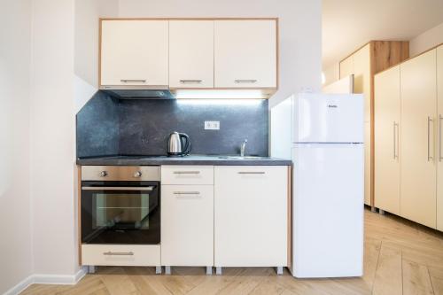 a kitchen with white cabinets and a refrigerator at WOW studios for rent - bul Montevideo 25A - B in Sofia