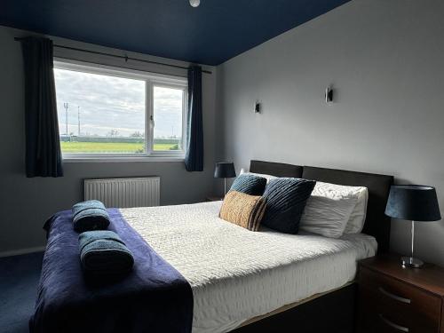 a bedroom with a large bed with a window at Blackwater Terrace Witham 