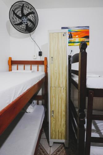 a room with two bunk beds and a door at Hostel Cabo Frio in Cabo Frio