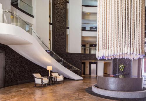 a lobby with a white staircase and a table and chairs at Hilton Vacation Club Cabo Azul Los Cabos in San José del Cabo