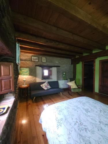 a bedroom with a bed and a couch in a room at Hotel Rural La Encantada en Riaza in Becerril