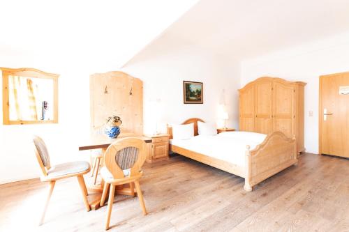Schlafzimmer mit einem Bett, einem Schreibtisch und Stühlen in der Unterkunft Gasthof Engel in Obergünzburg