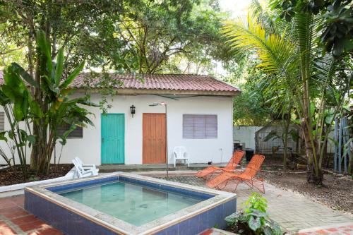 una pequeña casa con piscina frente a ella en Hotel Villa Ivel, en Turbaco