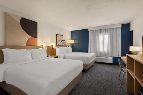 una camera d'albergo con due letti e una finestra di Spark By Hilton Fort Wayne a Fort Wayne