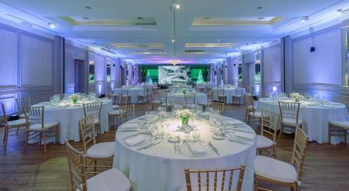 un salón de banquetes con mesas y sillas blancas en Grand Hyatt La Manga Club Golf & Spa, en La Manga del Mar Menor