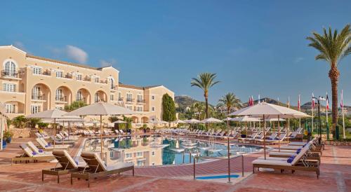 a resort with a swimming pool with chairs and umbrellas at Grand Hyatt La Manga Club Golf & Spa in La Manga del Mar Menor