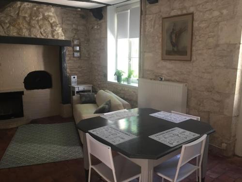 un salon avec une table et un canapé dans l'établissement Logement Château de Villeneuve, à Saint-Pardoux