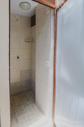 a bathroom with a shower with white tile at Hostel Cabo Frio in Cabo Frio