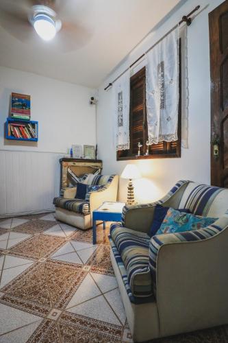 a living room with two couches and a table at Hostel Cabo Frio in Cabo Frio