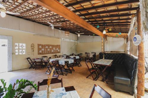 a restaurant with tables and chairs in a room at Hostel Cabo Frio in Cabo Frio