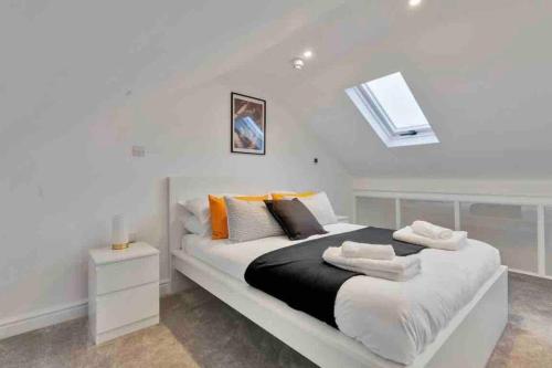a white bedroom with a large bed with pillows at 2 Bedroom City Centre Apartment with Free Parking in Gloucester