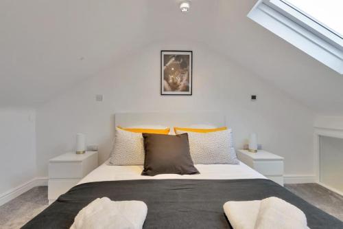 a white bedroom with a large bed with pillows at 2 Bedroom City Centre Apartment with Free Parking in Gloucester
