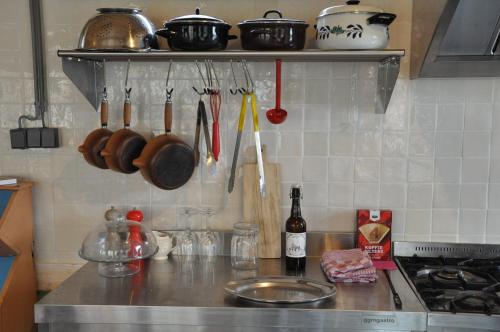 a kitchen counter with utensils on a shelf above a stove at Large cottage on sheepfarm in Amsterdam