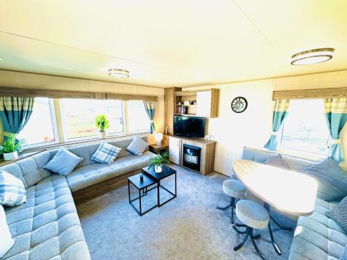a living room with a couch and a tv at Dunlin Retreat in Flamborough