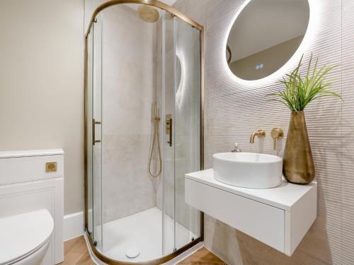 a bathroom with a shower and a sink and a mirror at Old Bank House in Barnard Castle