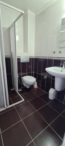 La salle de bains est pourvue de toilettes et d'un lavabo. dans l'établissement California Apart Otel, à Ölüdeniz