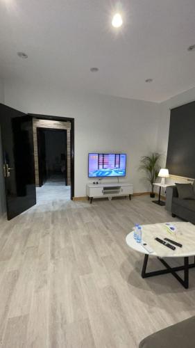 a living room with a flat screen tv on a wall at فندق أسرار العلا الفندقية in Al-ʿUla