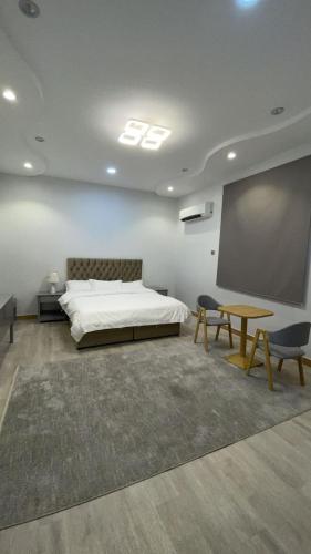 1 dormitorio con cama y pantalla de proyección en فندق أسرار العلا الفندقية, en Al Ula