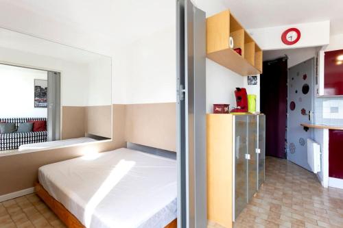 - une petite chambre avec un lit et un réfrigérateur dans l'établissement Chez Stéphanie Vi - Fantastique appartement à proximité des plages, à La Grande Motte