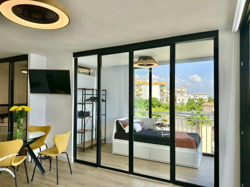 ein Schlafzimmer mit einem Bett und einen Balkon mit einem Tisch und Stühlen in der Unterkunft Apartamento Calma Las Conchas in Torremolinos