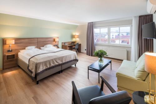a hotel room with a bed and a couch at Best Western Plus Hotel Excelsior in Erfurt