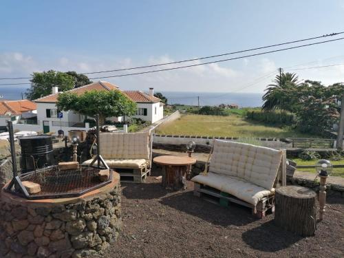 a patio with two chairs and a table and a fire pit at O Antigo Lagar in Cinco Ribeiras