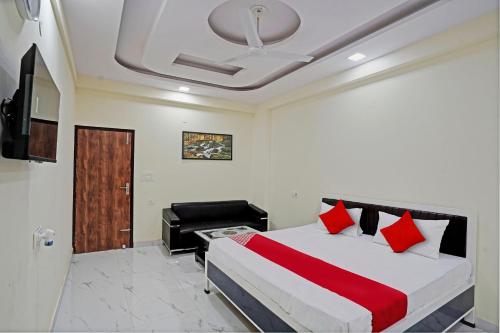 a bedroom with a bed and a couch and a television at OYO Flagship Hotel Jojo In in Ghaziabad