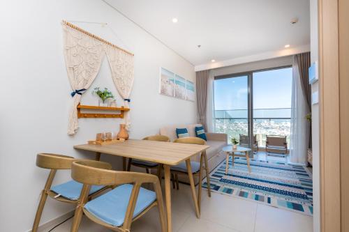 a dining room and living room with a table and chairs at The Sóng Luxury Apartment Vung Tau - Tuấn Hoà Homestay in Vung Tau