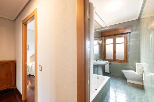 ein Badezimmer mit einer Badewanne, einem WC und einem Waschbecken in der Unterkunft Apartamento La Vega de Santiago 2 in Posada de Llanes
