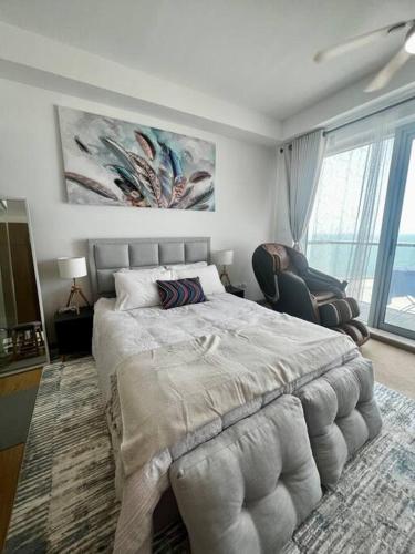 a bedroom with a large bed and a large window at Luxury Seaview Studio Apartment -RAK Marjan Island in Ras al Khaimah