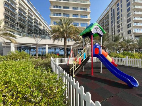un parque infantil con un tobogán frente a un edificio en Luxury Beachfront Studio Apartment Marjan Island, en Ras al Khaimah