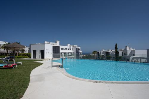 een groot zwembad met gebouwen op de achtergrond bij El Sol Higueron West Apartment in Fuengirola