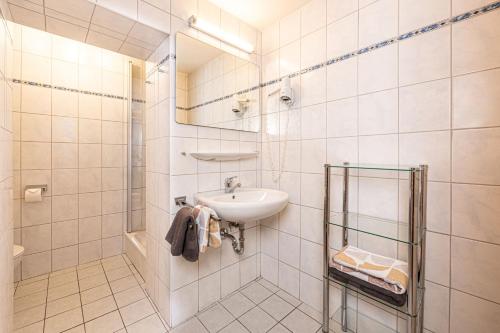a white bathroom with a sink and a shower at Gästehaus Bodnerlehen in Schönau am Königssee