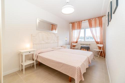 um quarto branco com uma cama e uma janela em Apartamento perfecto en Sitges em Sitges
