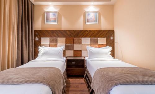 two beds in a hotel room with two bedsvisor at Dreamland Oasis Hotel Chakvi in Chakvi