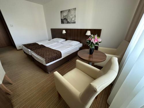 Habitación de hotel con cama, mesa y sillas en Hotel Bratislava en Bratislava