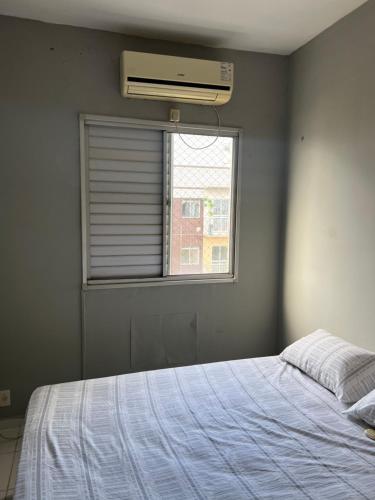 een slaapkamer met een wit bed en een raam bij Belo Apartamento em Condomínio in Ananindeua