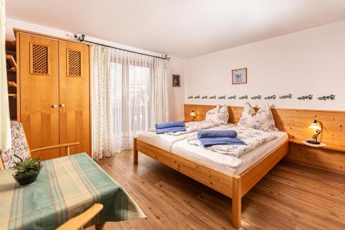 a bedroom with a bed and a table in it at Gästehaus Bodnerlehen in Schönau am Königssee