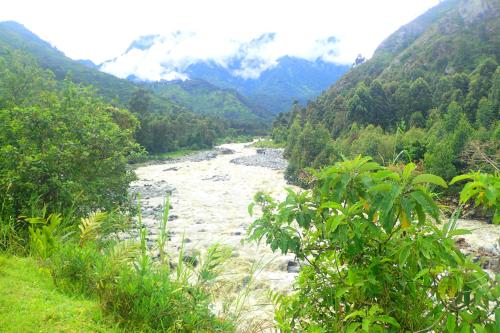 a river in the middle of a valley with mountains at Summit Guesthouse in Kasese