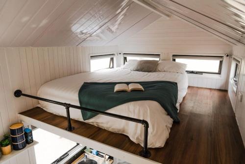 a bed in the middle of a tiny house at Odyssean Tiny House B in Cessnock