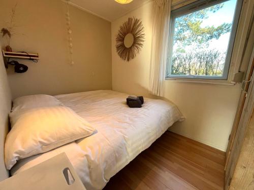 Habitación con cama con espejo y ventana en Vakantiebungalow Vrijzicht en Kortgene