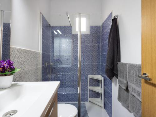 a bathroom with a toilet and a shower with blue tiles at EK Los Eucaliptos Fasnia in Fasnia