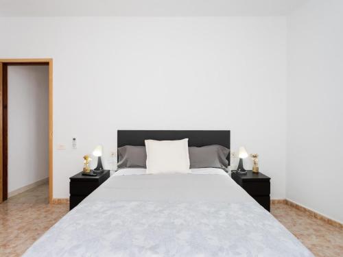 ein Schlafzimmer mit einem großen weißen Bett mit zwei Nachttischen in der Unterkunft EK Los Eucaliptos Fasnia in Fasnia